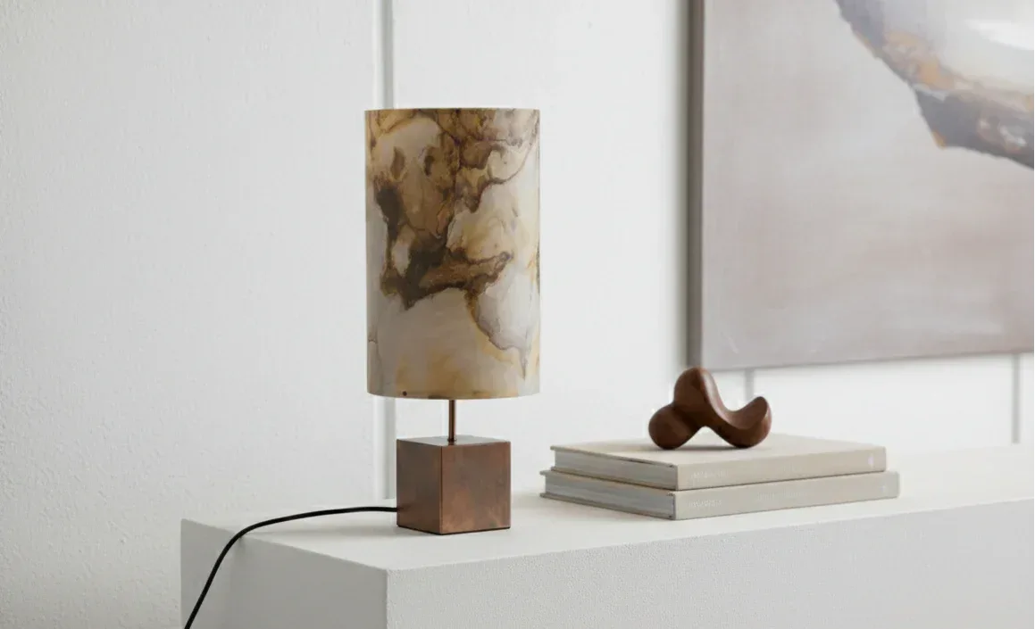 Lampe Halley de l'atelier Maus en acier cuivré et feuille d'ardoise mica ou pierre de lune sur une console de style contemporain en bois blanc laqué - Atelier Maus.