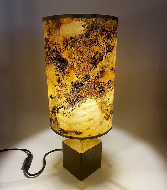 Lampe à poser Halley allumée – abat-jour ardoise pierre de lune et poudre de laiton, socle cube laiton – Atelier Maus
