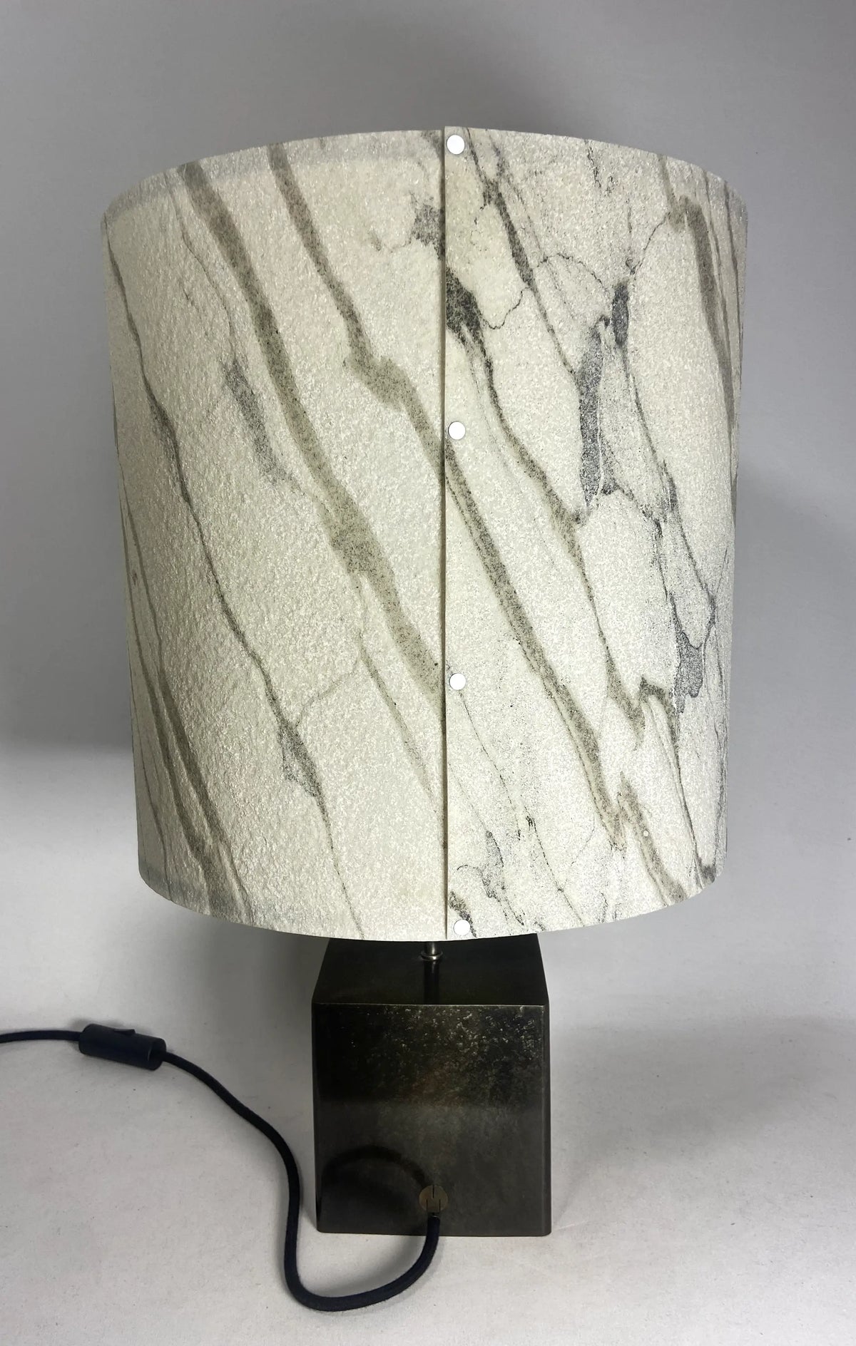 Vue arrière de la Lampe Cassini Nova en acier patiné brun noir , abat-jour en feuille de  marbre statuaire assemblé par rivets blancs. Pièce unique de Fabrication française Atelier Maus