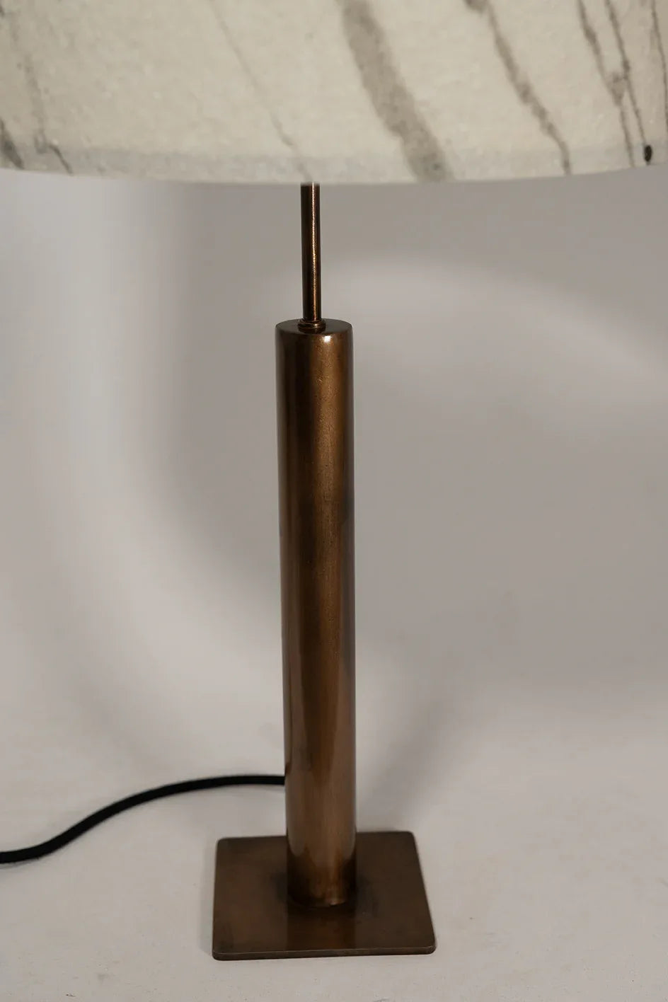 Photo en gros plan du pied de la lampe Rosalynd en acier cuivré et feuille de marbre Statuario | Atelier Maus