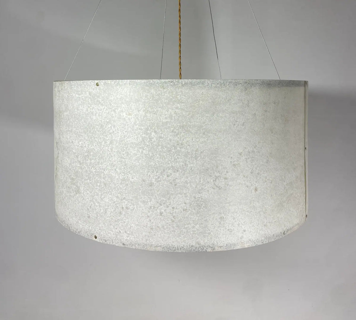 Vue rapprochée du mica et de la carcasse de l'abat-jour de la suspension en feuille de mica vert gris naturelle de 63 cm allumée - Collection Thessalie de l'atelier Maus - Pièce unique de fabrication artisanale française