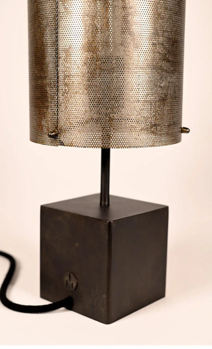 Détail des micro-perforations de l'abat-jour en tôle oxydée et de la patine noire